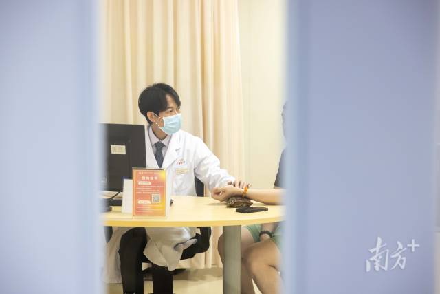 梁偉衡在給病人看診。